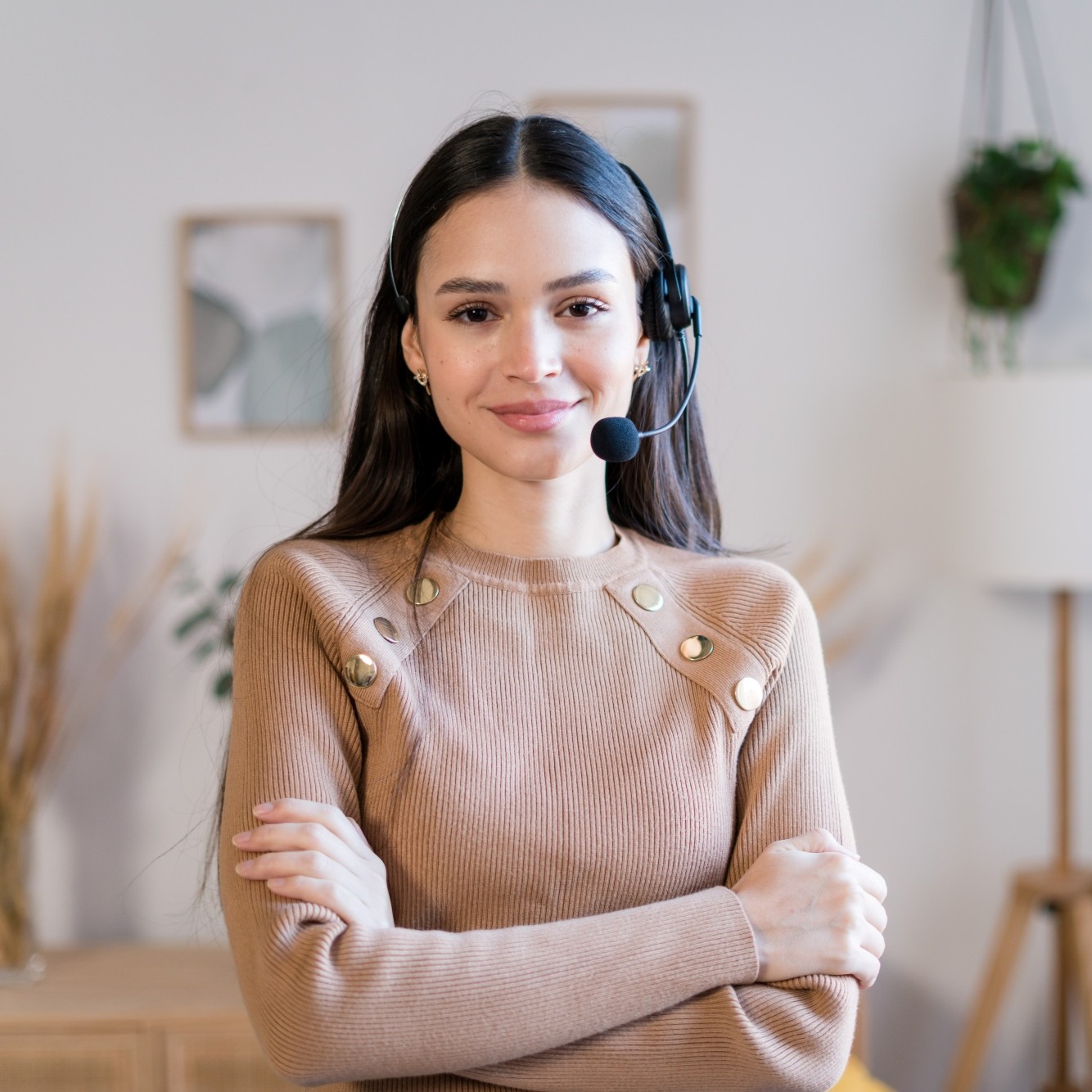 A friendly virtual assistant wearing a headset, smiling with arms crossed in a bright, plant-filled home office